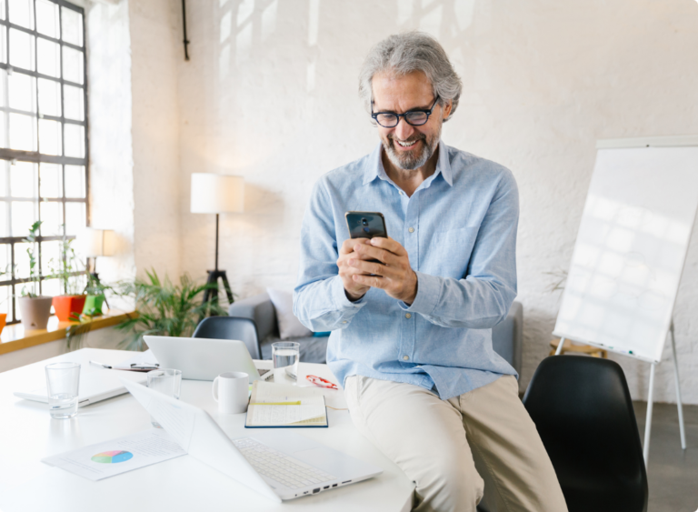 Ageing male entrepreneur with glasses on mobile